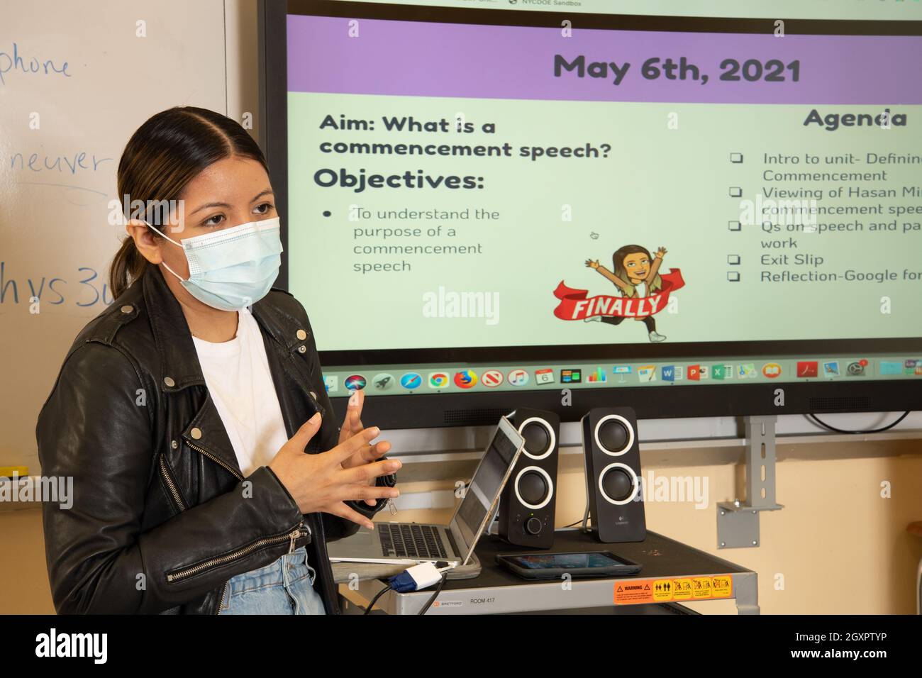 Éducation secondaire scène de salle de classe enseignante femme présentant à la classe électronique Smart board derrière elle, portant un masque de protection contre Covid Banque D'Images