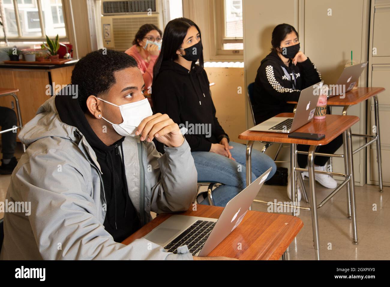 Éducation scène de classe de lycée, les élèves écoutent, tous portant des masques pour protéger contre l'infection Covid-19 Banque D'Images