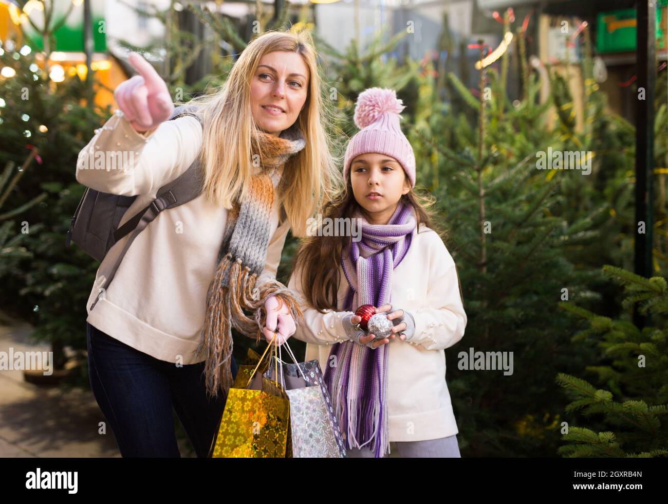 Préteen fille avec la mère sélectionnant arbre de Noël sur la foire extérieure Banque D'Images