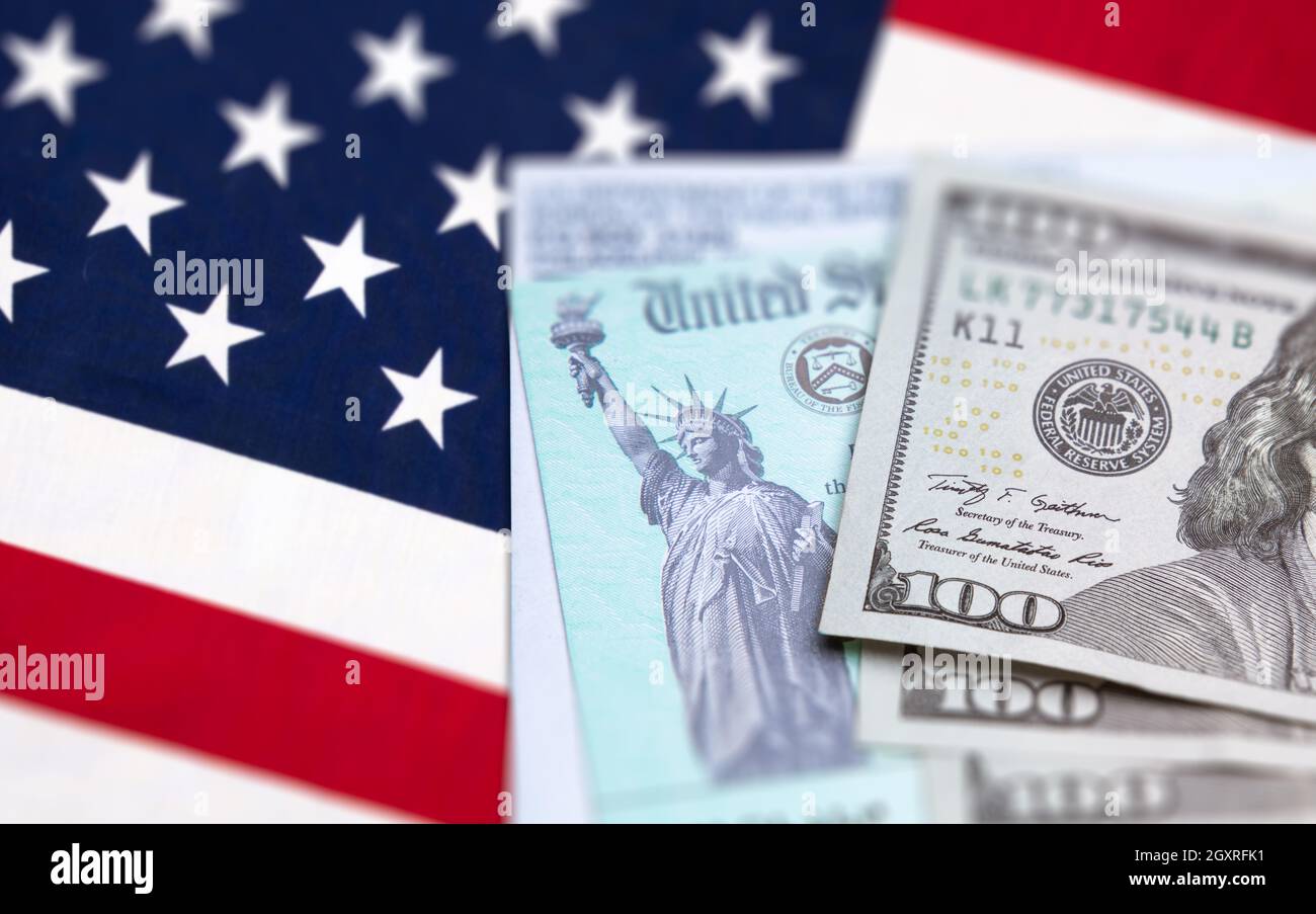 États-Unis IRS chèque, enveloppe et argent reposant sur le drapeau américain. Banque D'Images