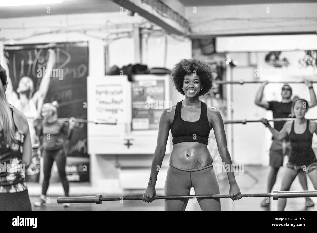 Beaux jeunes african american woman in sport fitness bar vide de levage Banque D'Images