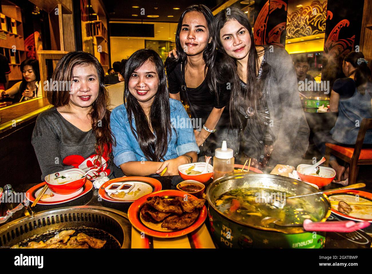 4 belles filles thaïlandaises ayant de la nourriture thaïlandaise avec une table pleine Banque D'Images