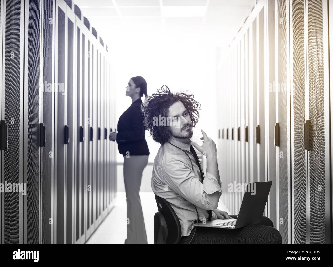 Équipe de jeunes techniciens qui travaillent ensemble sur les serveurs du datacenter à l'aide de l'ordinateur portable Banque D'Images