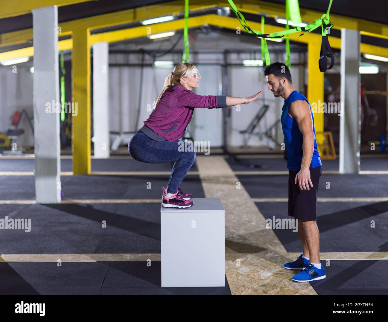 Jeune femme athlétique entraînement avec entraîneur personnel de sauter sur monter fort à crossfitness sport Banque D'Images