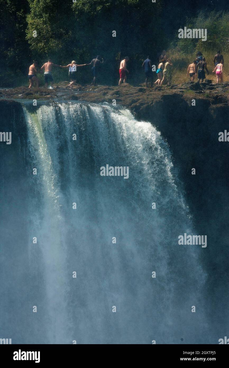 Touristes revenant de la piscine du diable sur les puissantes chutes Victoria sur le fleuve Zambèze, juste à la frontière de Zâmbia et Zimbabwe Banque D'Images