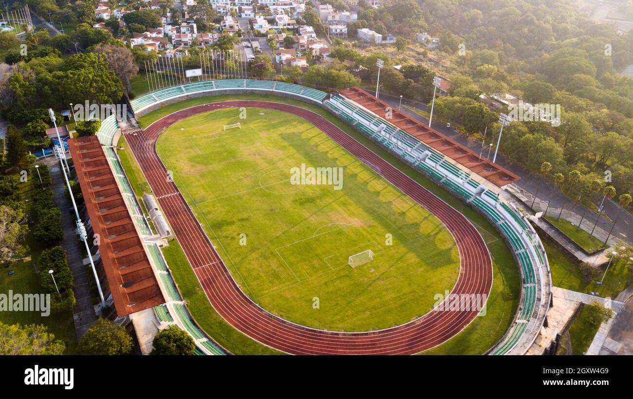 Vue aérienne sur la piste de course et le terrain de football entouré de maisons et d'arbres Banque D'Images