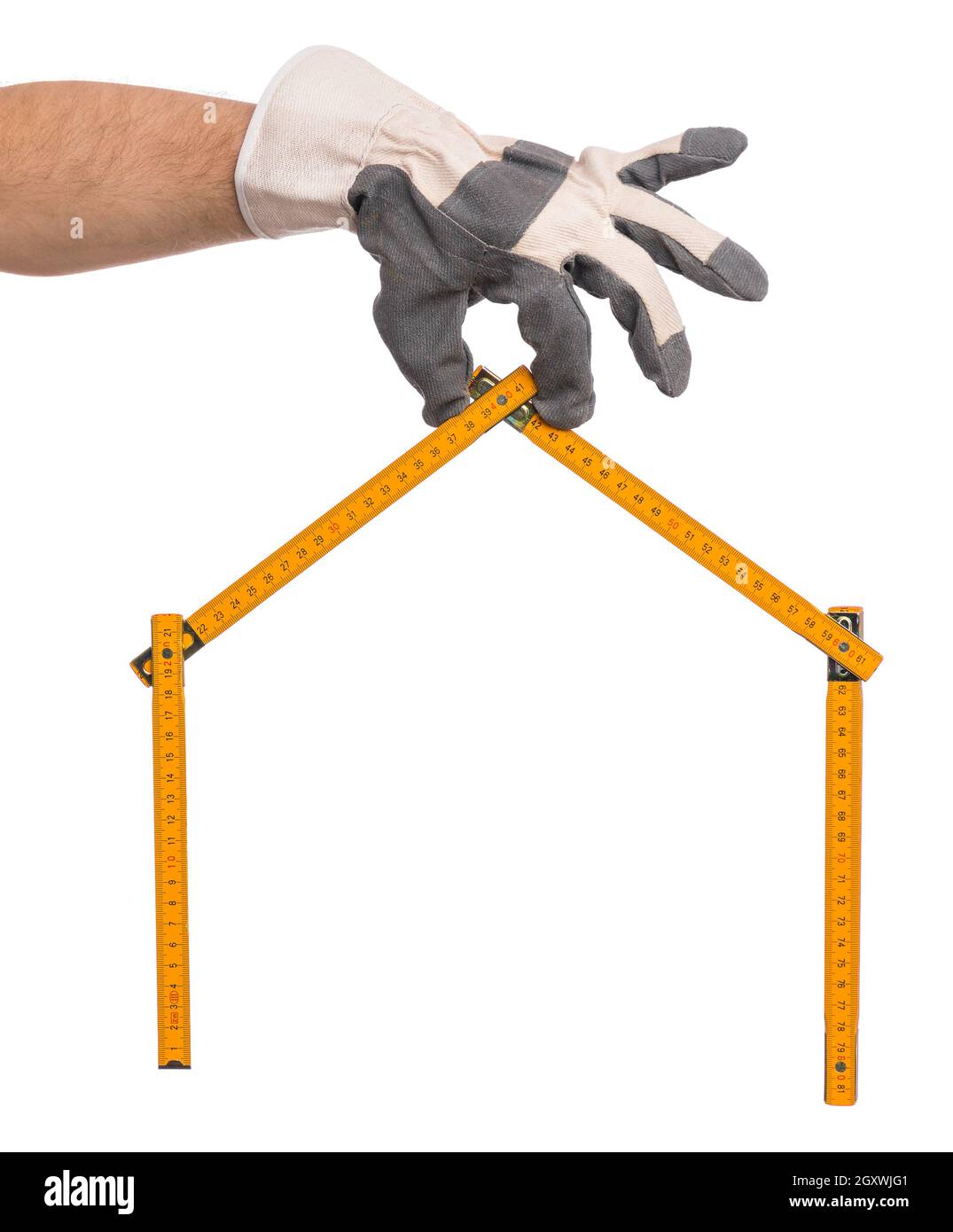 Homme main portant un gant de travail avec mètre en bois jaune en forme de maison.Outil de règle de maintien de main, isolé sur fond blanc. Banque D'Images