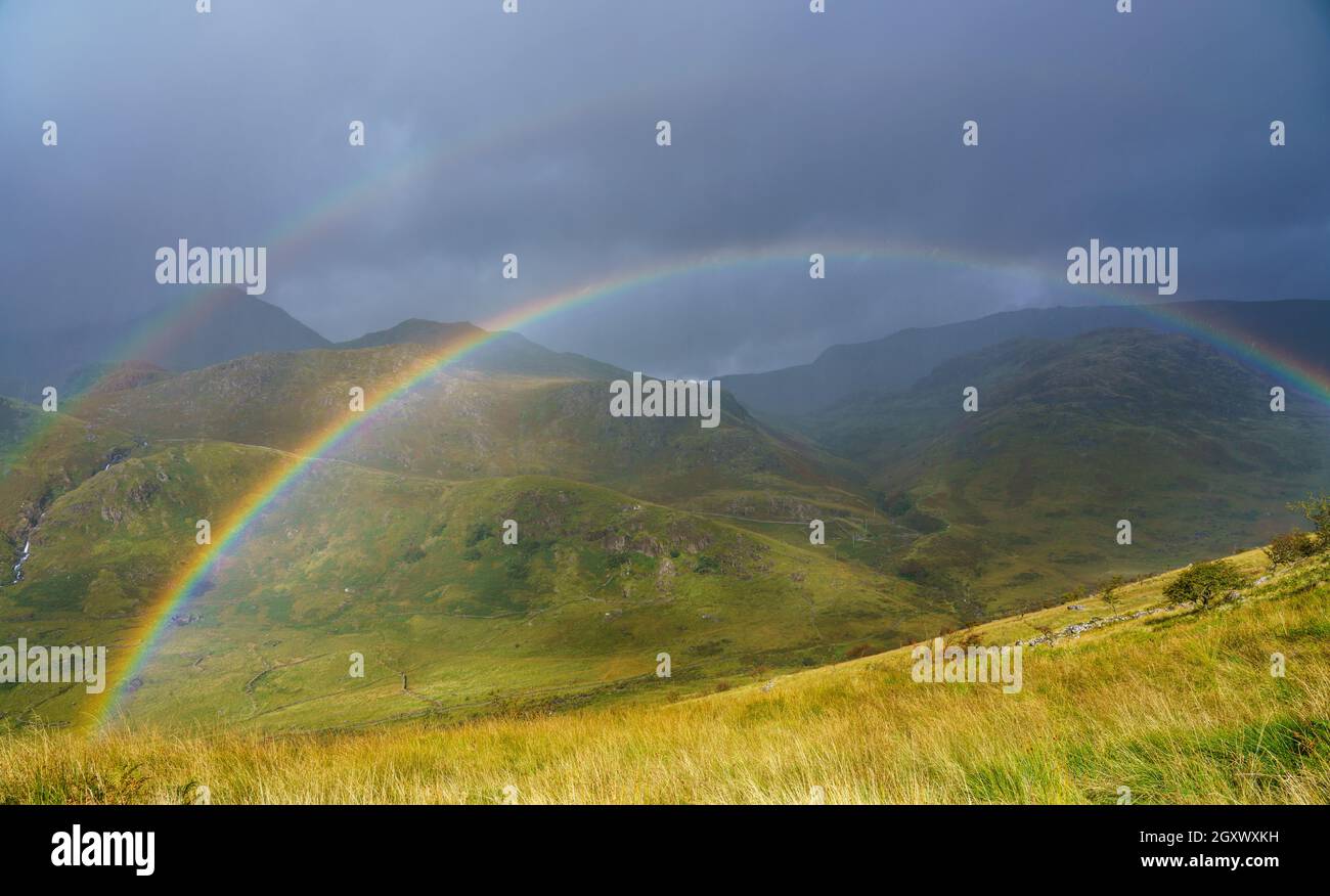 Vue panoramique avec un double arc-en-ciel sur les vallées et les montagnes dans le parc national de Snowdonia pays de Galles Banque D'Images