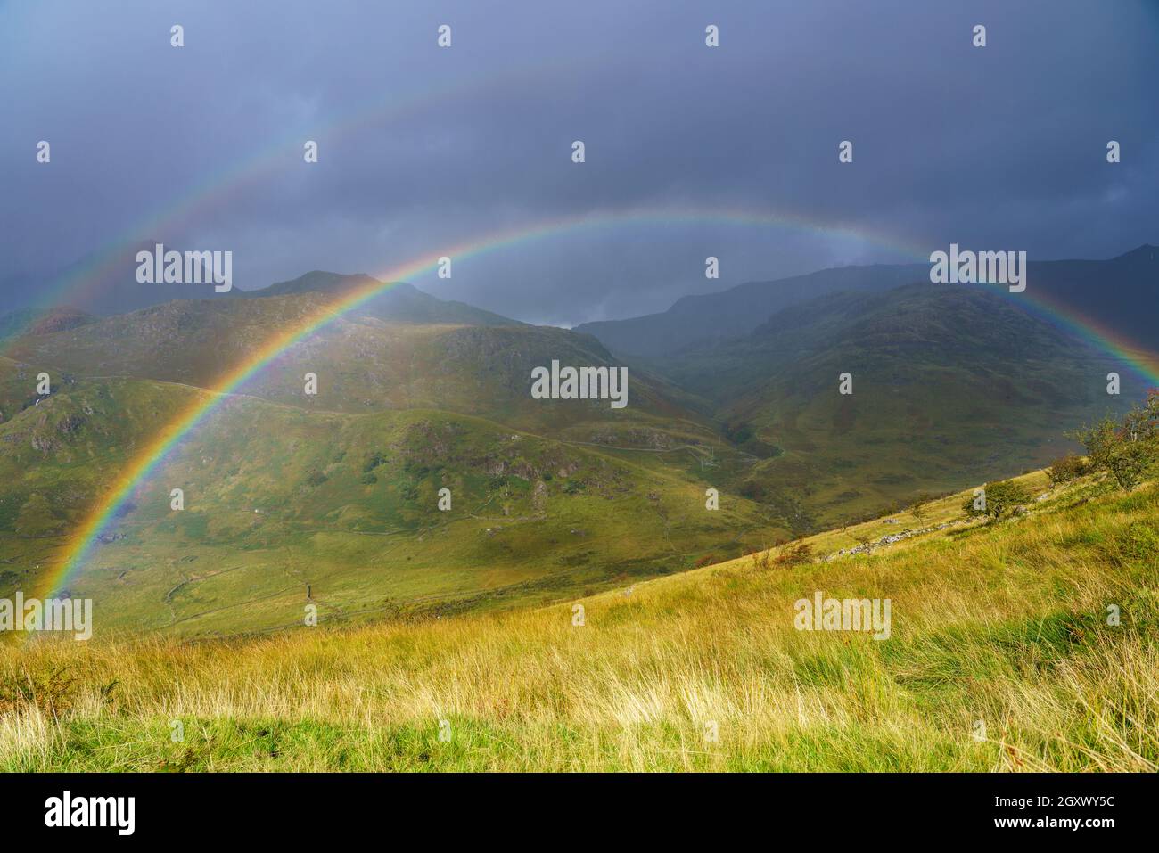 Vue panoramique avec un double arc-en-ciel sur les vallées et les montagnes dans le parc national de Snowdonia pays de Galles Banque D'Images
