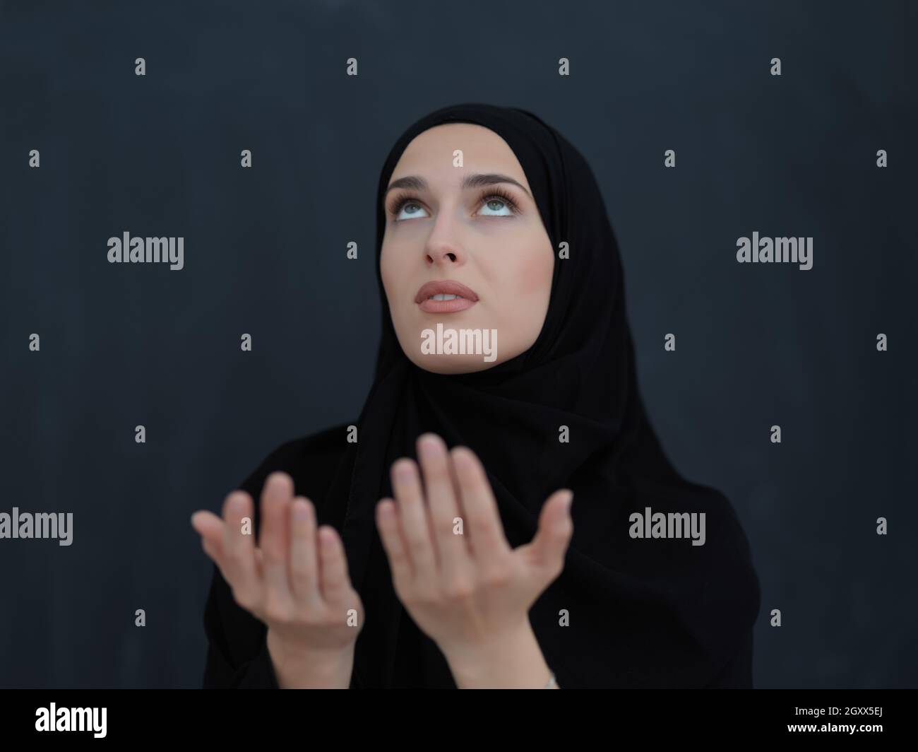 Portrait de la jeune femme musulmane faisant dua. La jeune fille arabe  portant l'abaya garde les mains dans le geste de prière. Représentant  l'adoration à Dieu et Ramadan Kareem c Photo Stock -