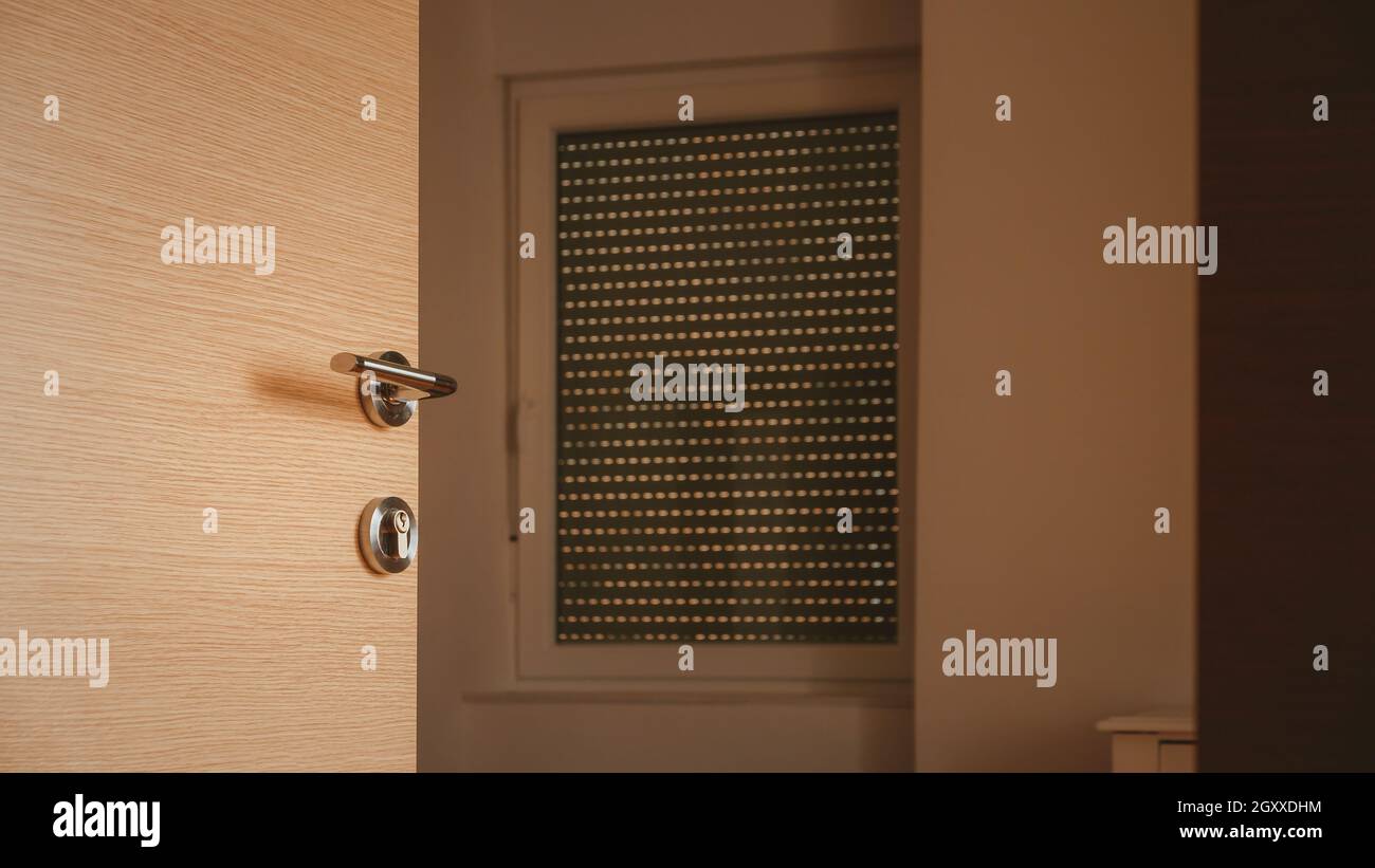 Poignée de porte métallique moderne sur porte de chambre en carton de densité moyenne, mise au point sélective Banque D'Images
