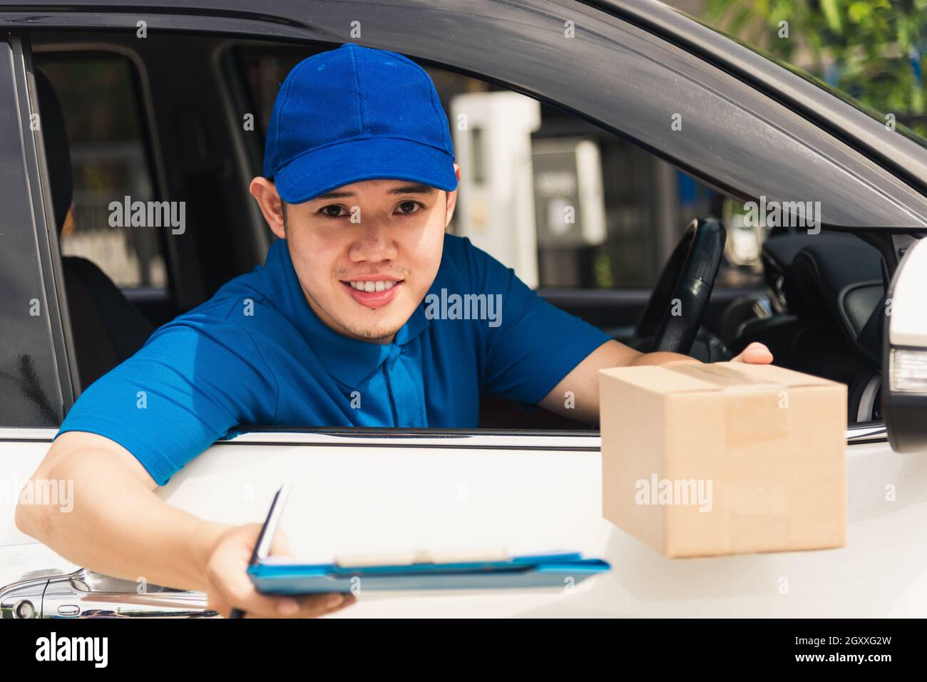 Un jeune livreur asiatique porte un uniforme dans la voiture