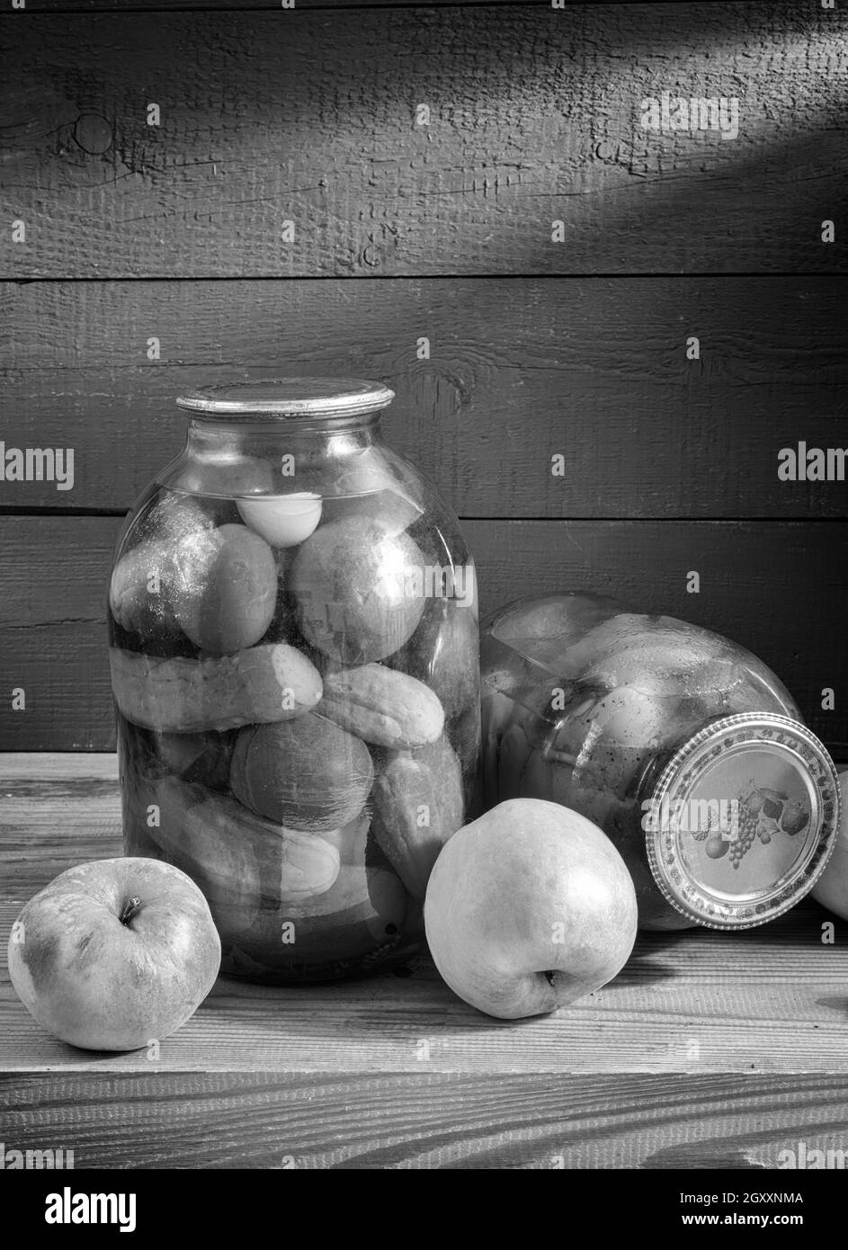Sur une étagère dans le sous-sol se trouvent deux bocaux en verre avec des tomates en conserve, des concombres et des poivrons. Scellé avec un couvercle étanche. Vue de face, espace de copie. Banque D'Images
