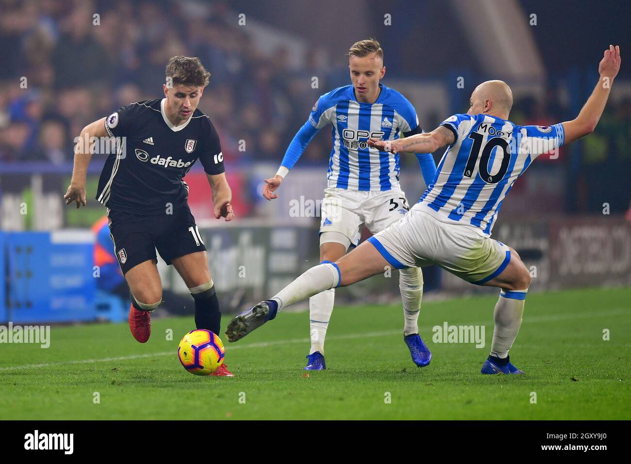 Tom Cairney, capitaine de Fulham, passe devant Aaron Mooy, de la ville de Huddersfield Banque D'Images