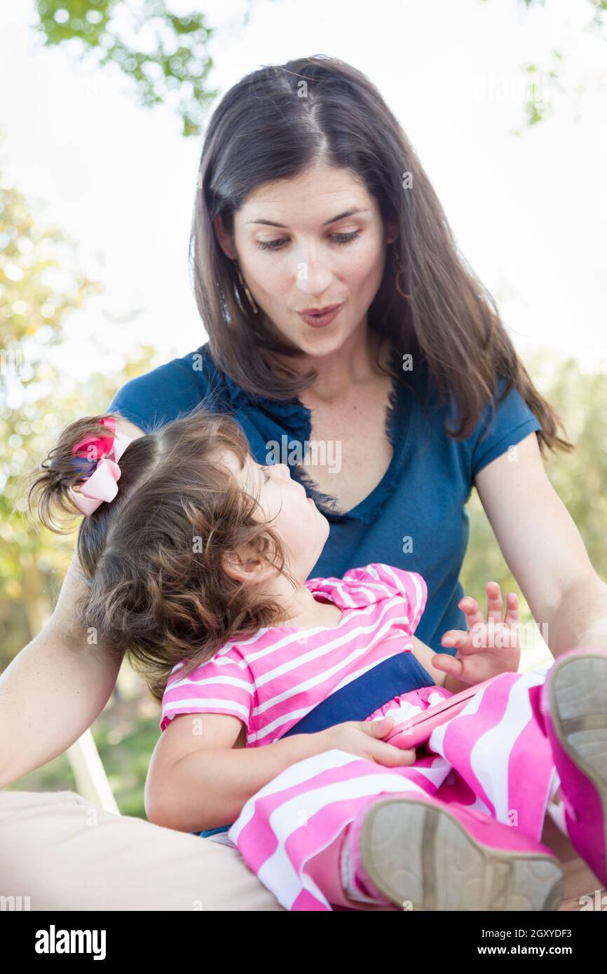 Mixed Race Mother et mignon bébé fille jouer avec un téléphone cellulaire  en parc Photo Stock - Alamy