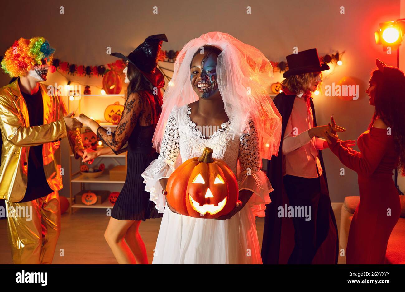 Portrait d'une jeune femme afro-américaine joyeuse habillée comme mariée zombie à la fête d'Halloween. Banque D'Images
