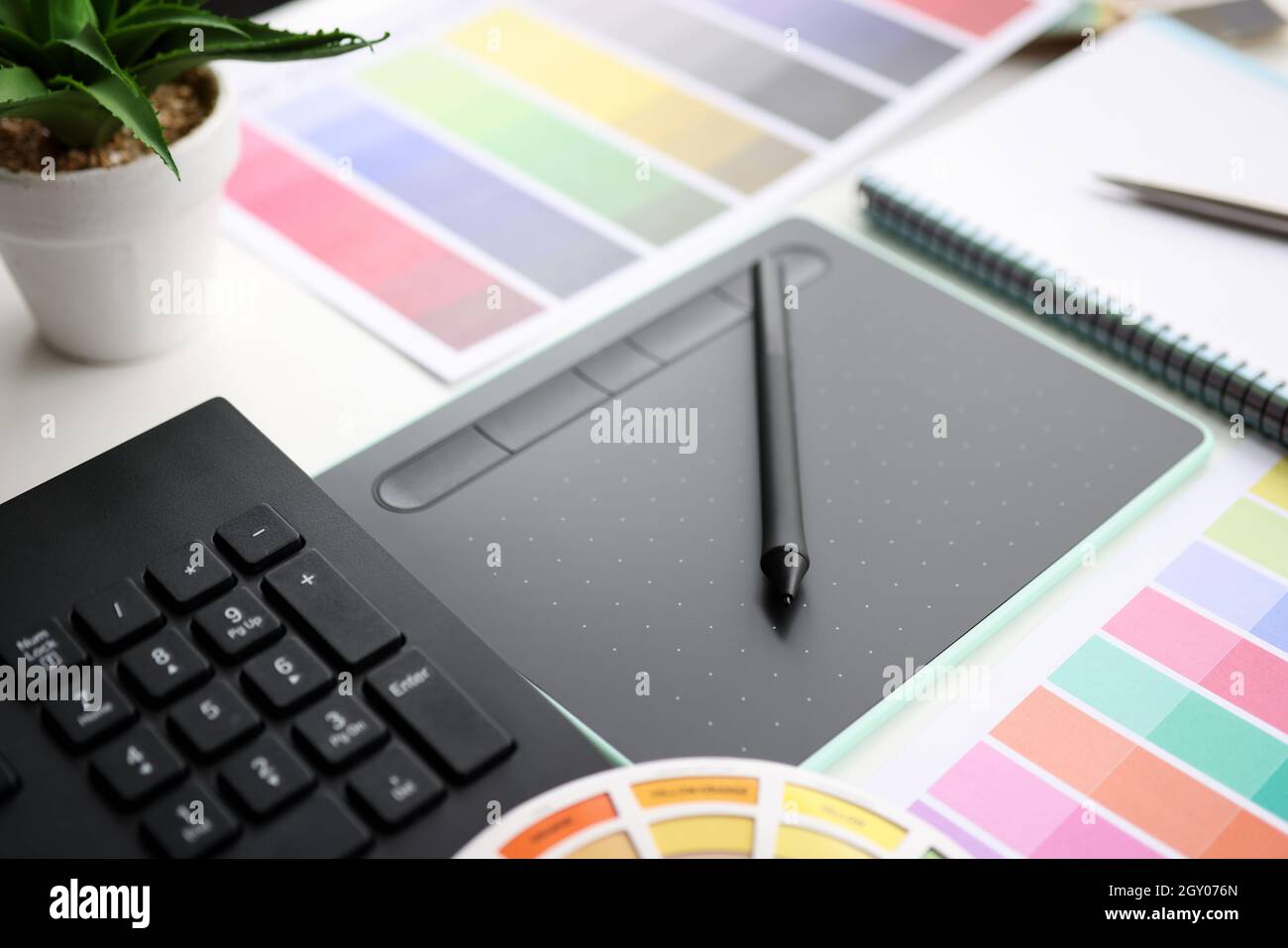 Tablette graphique avec stylet et palette de couleurs sur table Banque D'Images