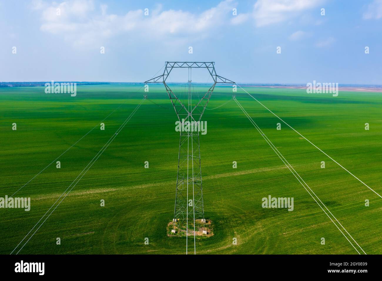 Vue aérienne en gros plan du pylône électrique avec lignes électriques sur le champ agricole. Banque D'Images
