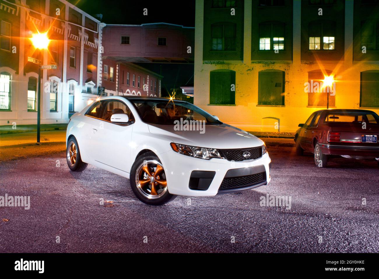 Voiture blanche dans un cadre urbain avec des lumières orange Banque D'Images