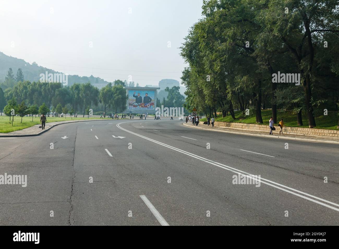 Pyongyang, Corée du Nord - 28 juillet 2014 : une route vide dans une rue de Pyongyang. Un panel représentant les dirigeants nord-coréens Kim il Sung et Kim Jong il on Banque D'Images