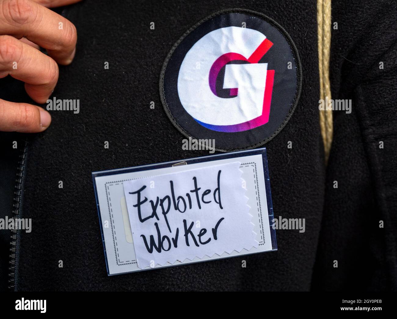 Berlin, Allemagne. 06e octobre 2021. Un travailleur du service de livraison express Gorillas porte un panneau avec l'inscription « travailleur exploité » lors d'une manifestation devant le siège de l'entreprise pour de meilleures conditions de travail. Les coursiers de gorilles sont frappants depuis des mois pour exiger des conditions de travail améliorées. Récemment, l'entreprise a mis fin à un certain nombre d'employés sans préavis. Credit: Monika Skolimowska/dpa-Zentralbild/dpa/Alay Live News Banque D'Images