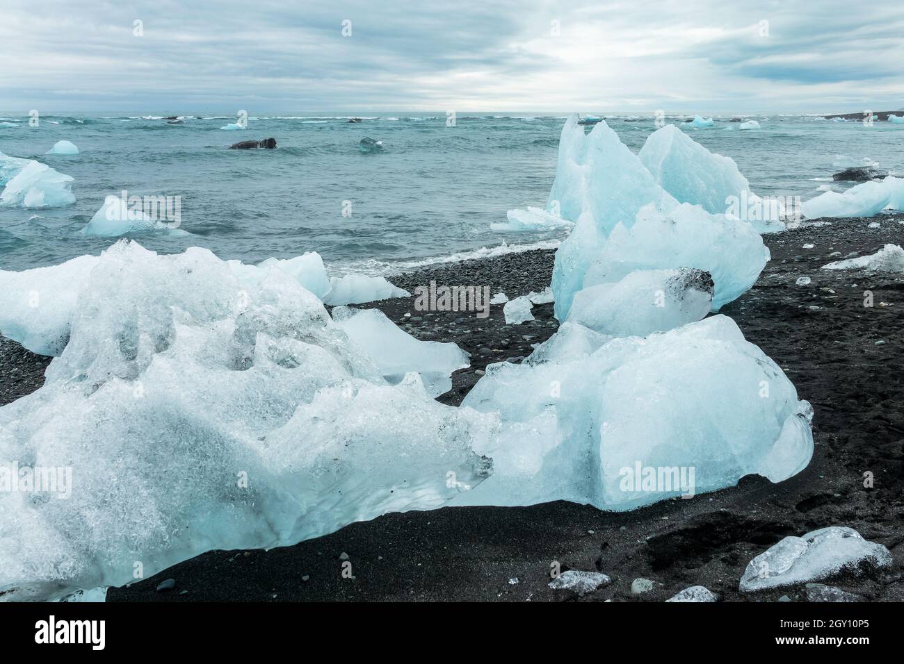 Icebergs et sable noir sur la plage de Jokulsarson Diamond, Islande Banque D'Images