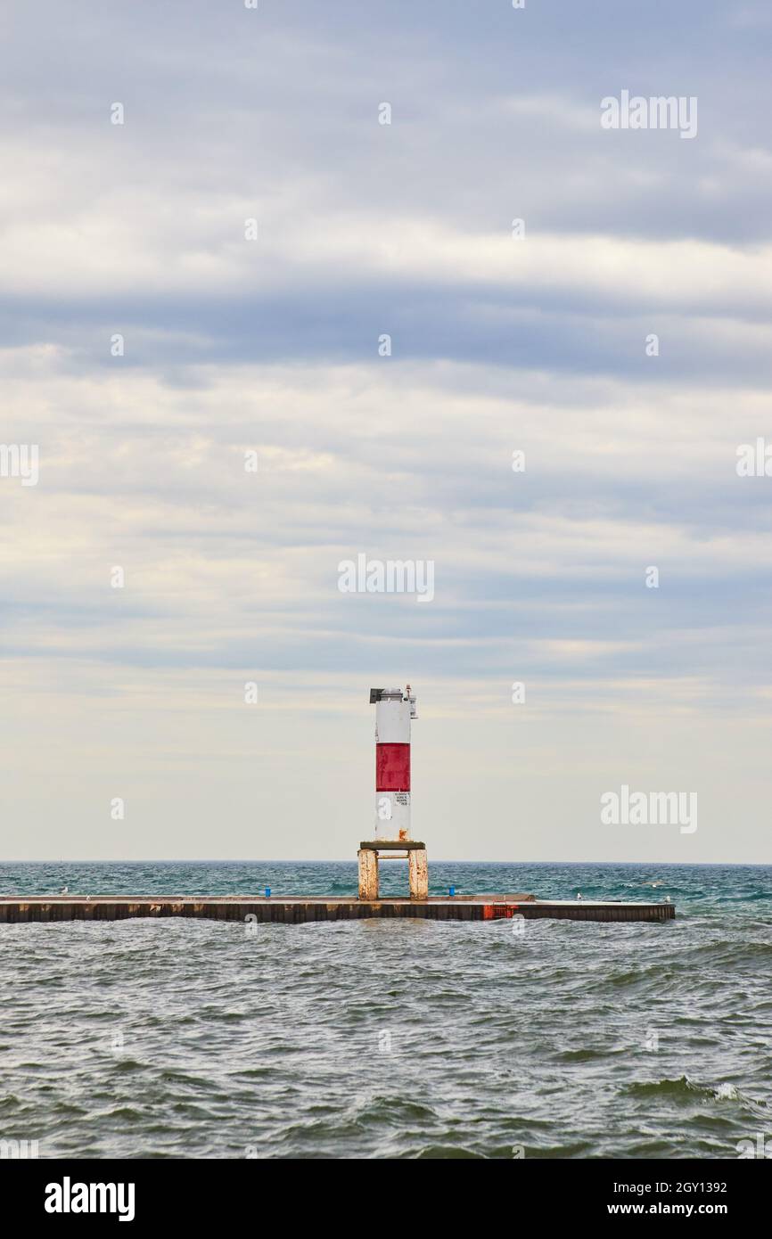 Jetée du lac avec structure d'avertissement rouge sur ciel nuageux Banque D'Images
