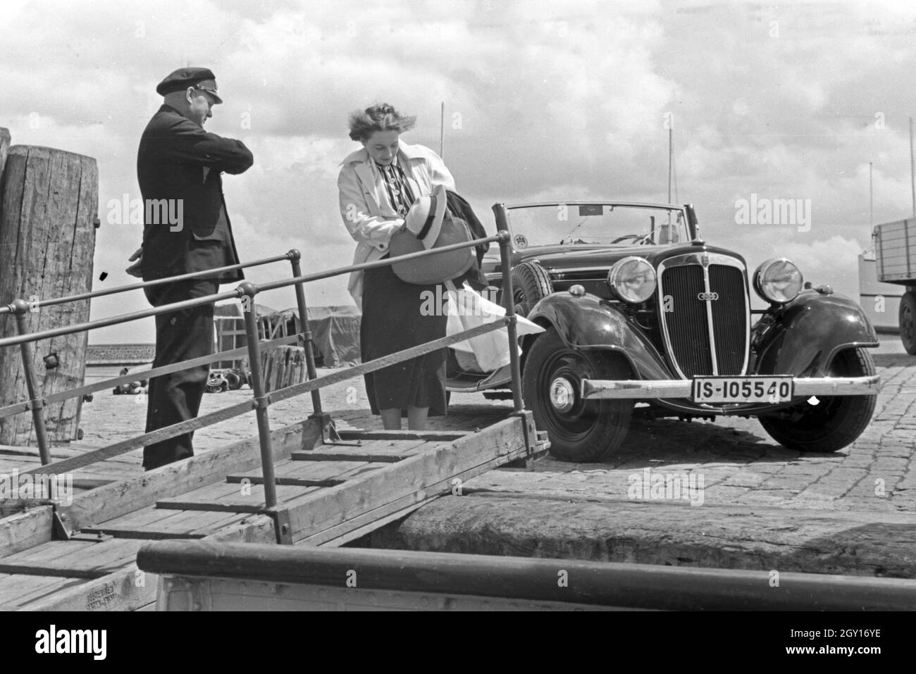 Eine Frau auf der erwartet Seemann une passerelle à Norddeich Mole vor ihrem Audi Cabrio, Deutschland 1930 er Jahre. Une femme et un marin se serrer la main par une passerelle en face d'une Audi cabriolet, Allemagne 1930. Banque D'Images