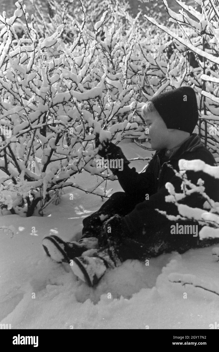 Ein kleiner Junge sitzt im Schnee, Deutschland 1930er Jahre. Un petit garçon assis dans la neige, l'Allemagne des années 1930. Banque D'Images