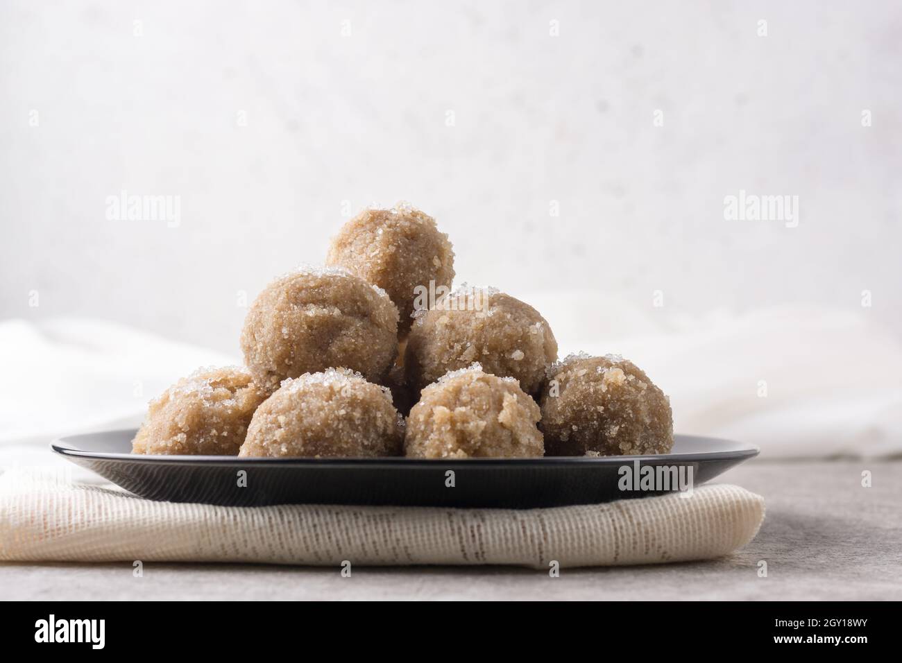 en-cas sucré, boulettes de riz et de noix de coco sur une assiette, sucre saupoudré sur le dessus, dessert sucré ou petit déjeuner Banque D'Images