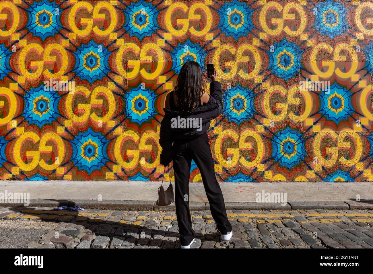 Londres, Royaume-Uni. 06e octobre 2021. Une jeune femme prend des photos de l'extérieur coloré du magasin. Un nouveau magasin éclair Gucci 'Circolo' ouvre ses portes dans le quartier branché de Shoreditch à Londres. Le magasin est doté d'un extérieur dynamique et d'un espace unique. Il restera ouvert pendant trois mois. Credit: Imagetraceur/Alamy Live News Banque D'Images