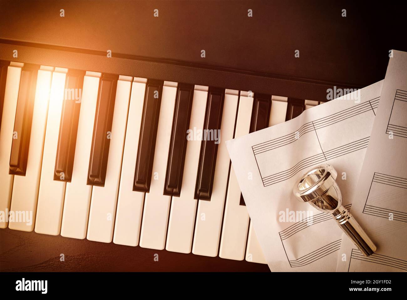 Instruments de laiton et concept de concert de piano avec fond de l'embout buccal sur les clés de piano et les draps du personnel.Vue de dessus.Composition horizontale. Banque D'Images