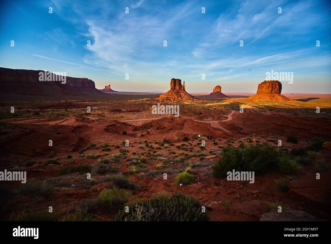 Grand cliché du désert avec une route de terre dans Monument Valley de grandes roches rouges et un ciel bleu Banque D'Images