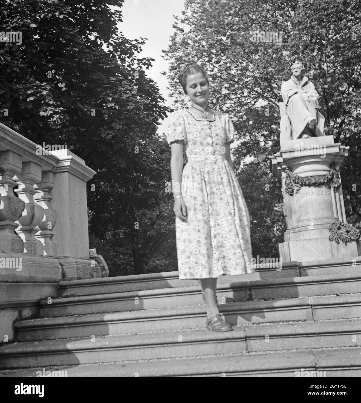 Eine junge Frau vor dem Denkmal von Justus von Liebig, Deutschland 1930er Jahre. Une jeune femme devant une sculpture de Jutus von Liebig, Allemagne des années 1930. Banque D'Images
