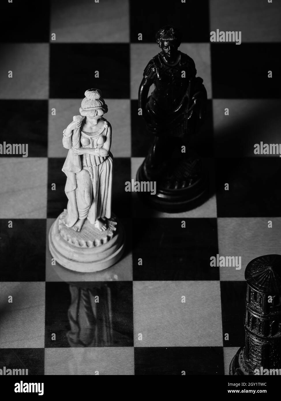 De vieilles pièces d'échecs sur un échiquier, une reine blanche et un roi noir Banque D'Images