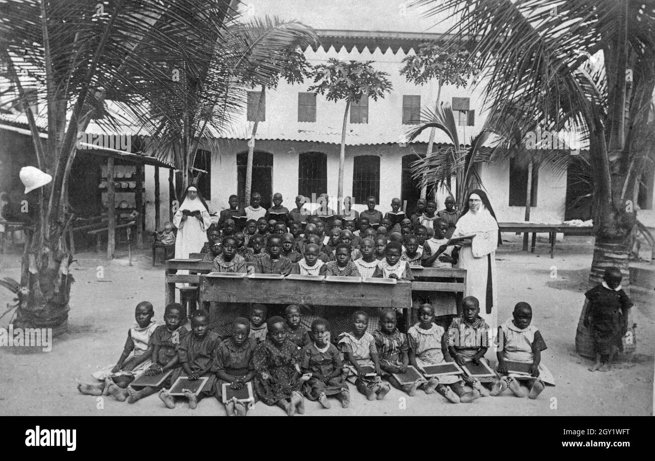 Klasse mit afrikanischen Schulkindern, die von Nonnen unterrichtet werden, Deutsch-Ostafrika 1900er Jahre. Classe d'enfants d'école africains, enseignée par des religieuses, Afrique de l'est allemande des années 1900. Banque D'Images