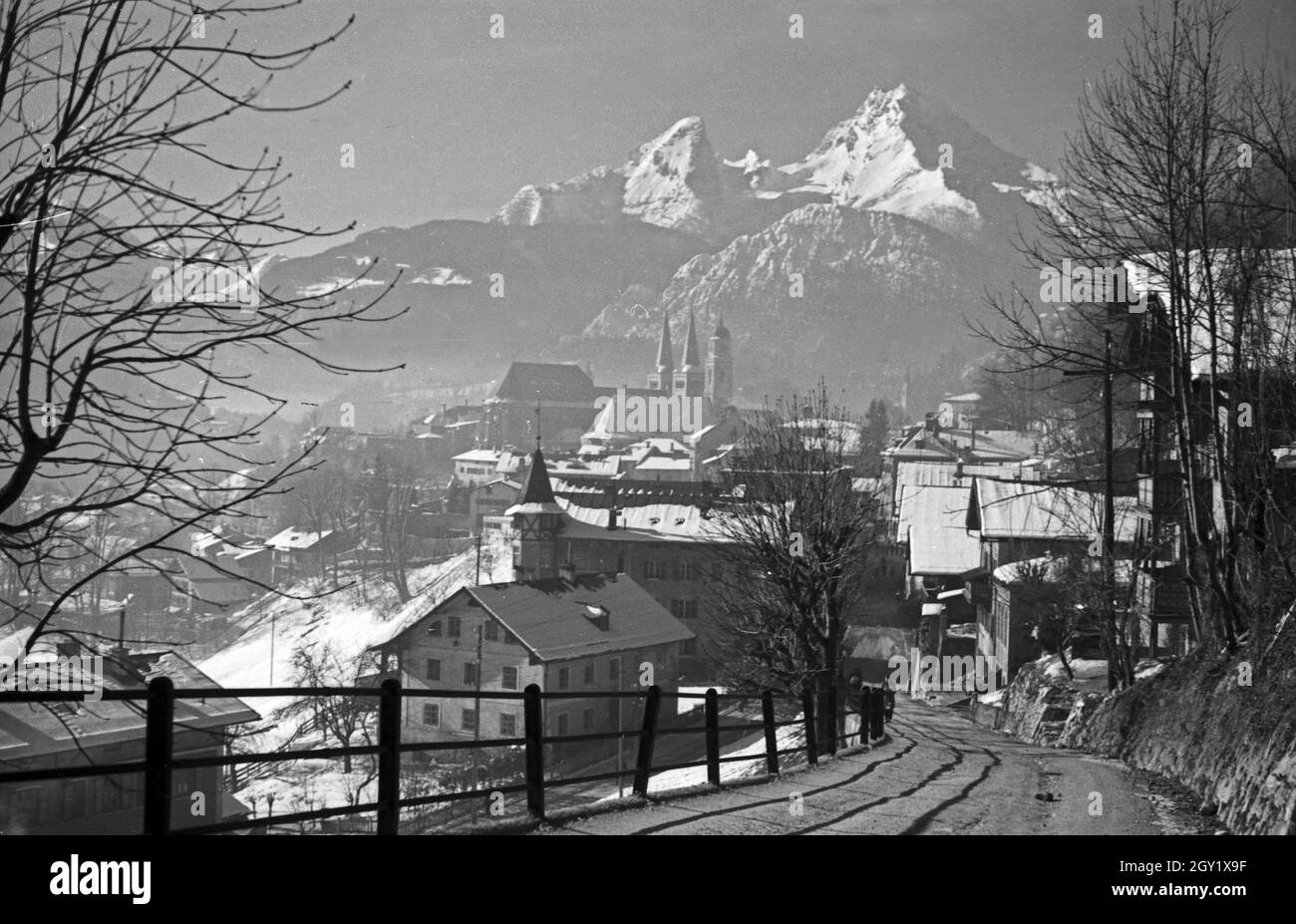 Unterwegs im Berchtesgadener Land, hier: Stadtansicht mit Blick auf die Stiftskirche und die Pfarrkirche, dahinter das Watzmannsund Deutschland 1940er Jahre. Autour de Berchtesgaden, ici : vue sur la ville, Allemagne des années 1940. Banque D'Images