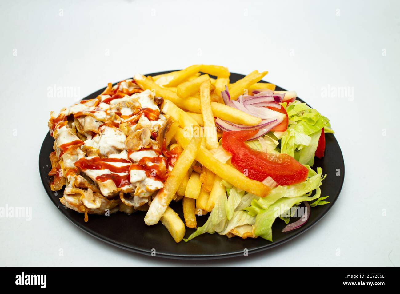 Donner kebab avec des chips et de la salade, sur une assiette noire isolée  sur fond blanc Photo Stock - Alamy