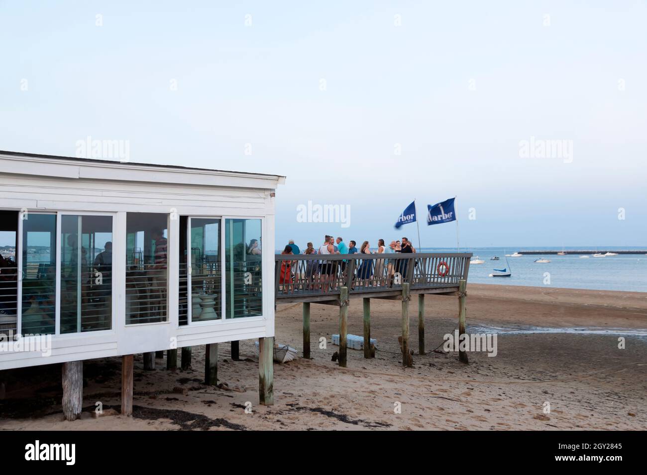 Les clients du salon Harbour profitent de boissons et de belles vues sur le front de mer au crépuscule à Provincetown, Massachusetts, États-Unis. Banque D'Images