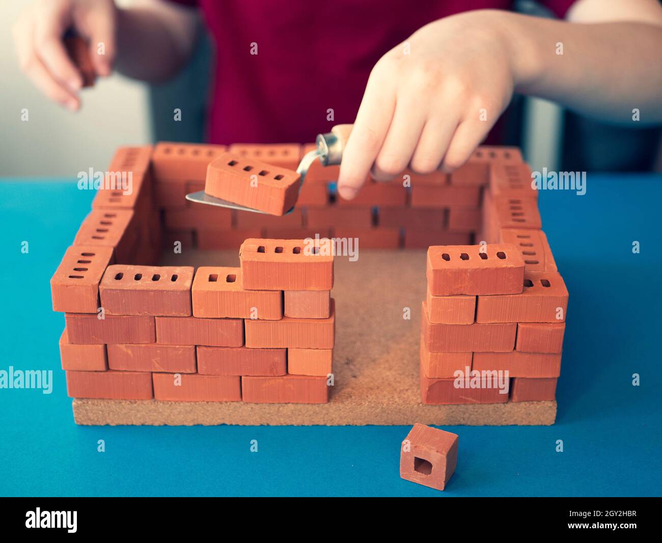 L'enfant crée une construction avec des briques de jouet et une truelle de  main.Concept de la profession d'ingénieur de structure, constructeur.Faire  une maison de jouets Photo Stock - Alamy