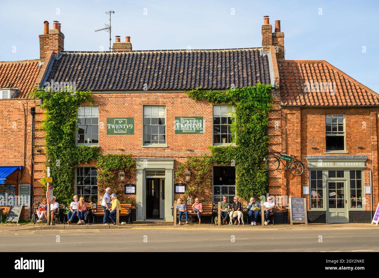 Les façades en briques rouges du Bar & Restaurant n° Twenty9 et de la boulangerie n° Thirty3 à Burnham Market, Norfolk, Angleterre. Banque D'Images