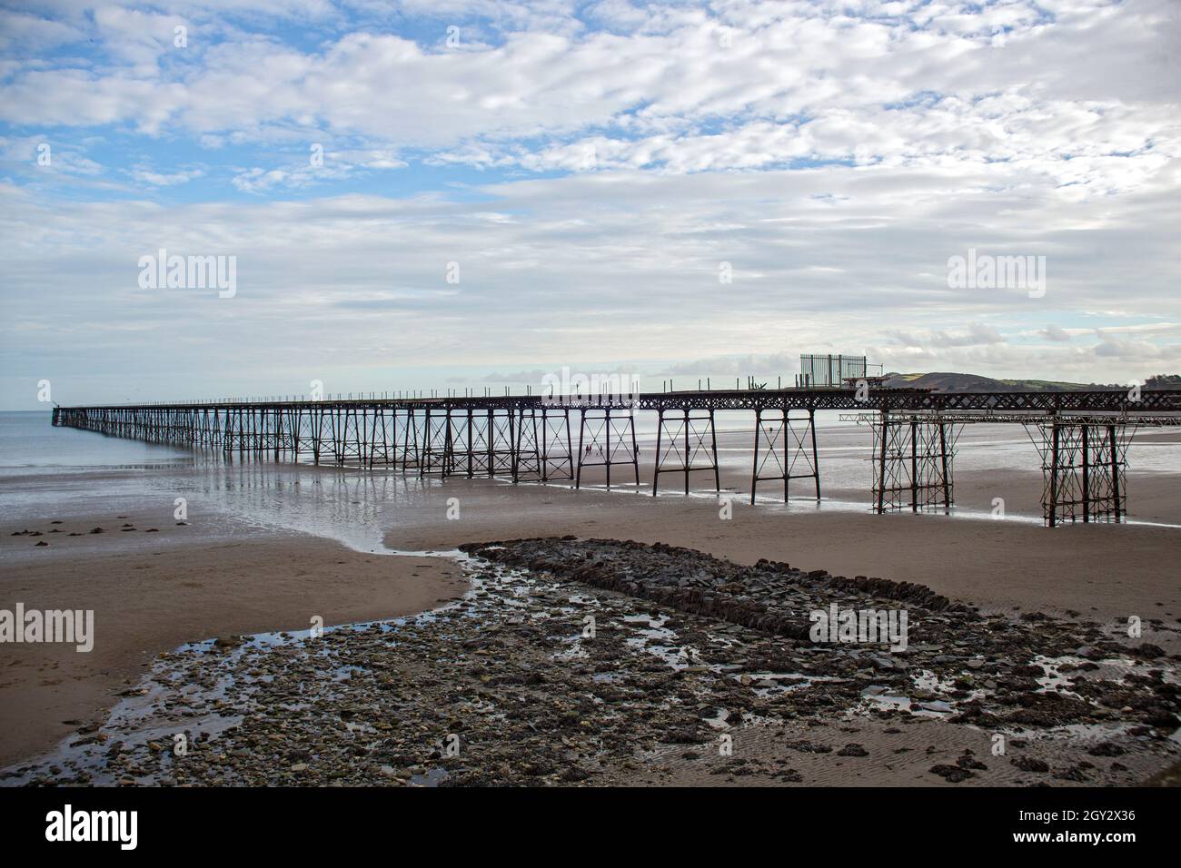 Image de la jetée de la Reine de l'époque victorienne, actuellement en cours de restauration à Ramsey, île de Man à marée basse dans des cieux lumineux mais nuageux. Banque D'Images