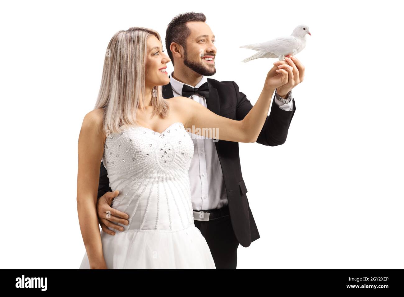 Photo de profil de la mariée et du marié tenant une colombe blanche isolée sur fond blanc Banque D'Images