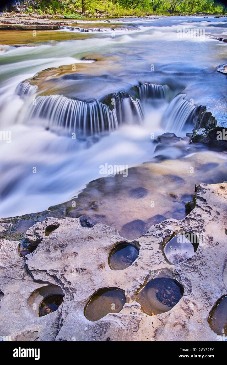 Côte rocheuse avec de petits trous à côté de petites cascades Banque D'Images