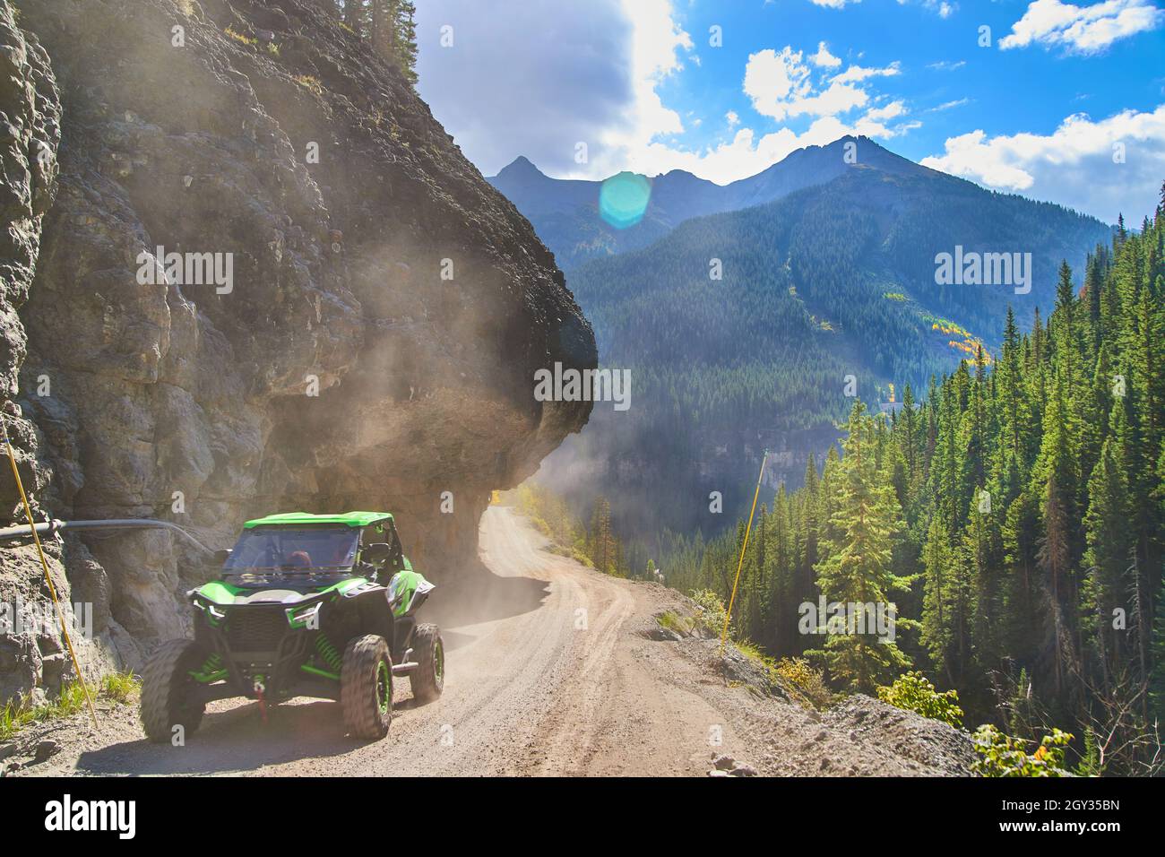 Véhicule à quatre roues roulant en montagne sur une route étroite Banque D'Images