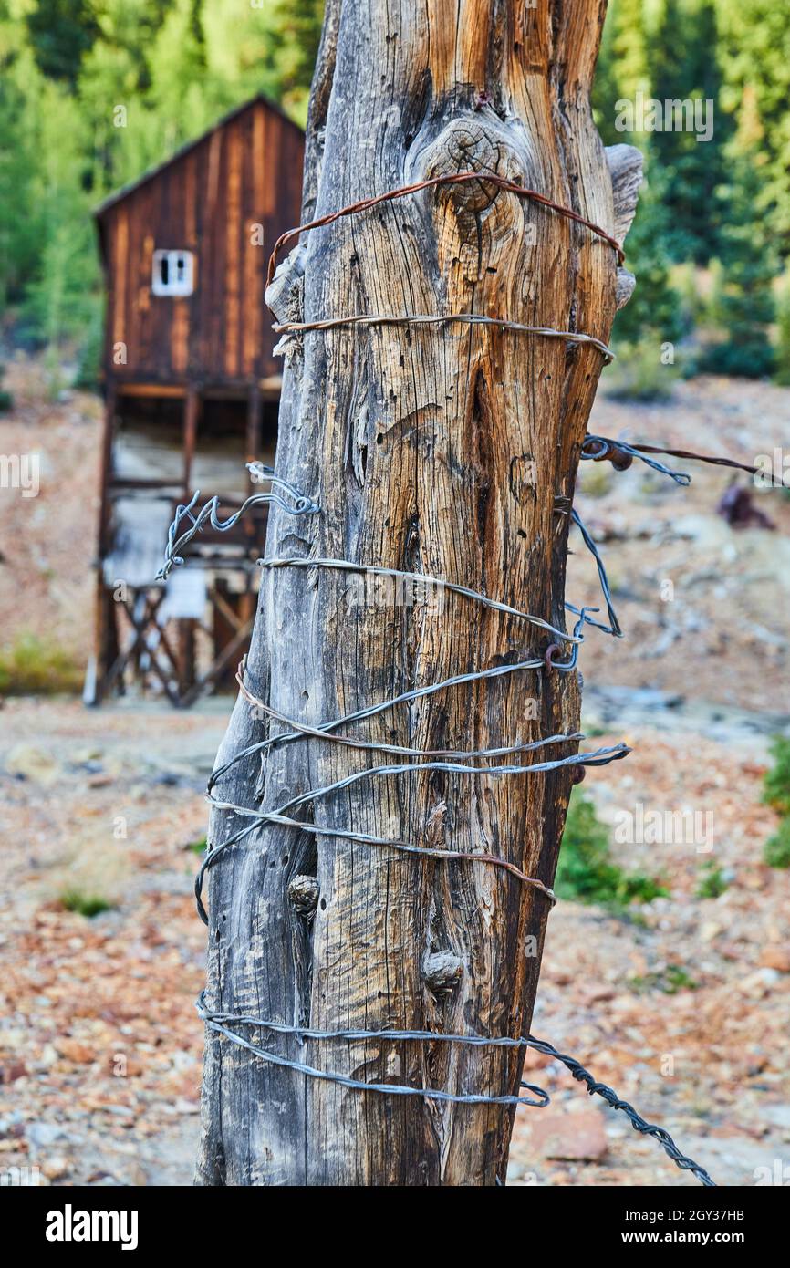 Coffre en bois enveloppé dans du fil métallique avec une ancienne structure d'exploitation minière du bois en arrière-plan Banque D'Images