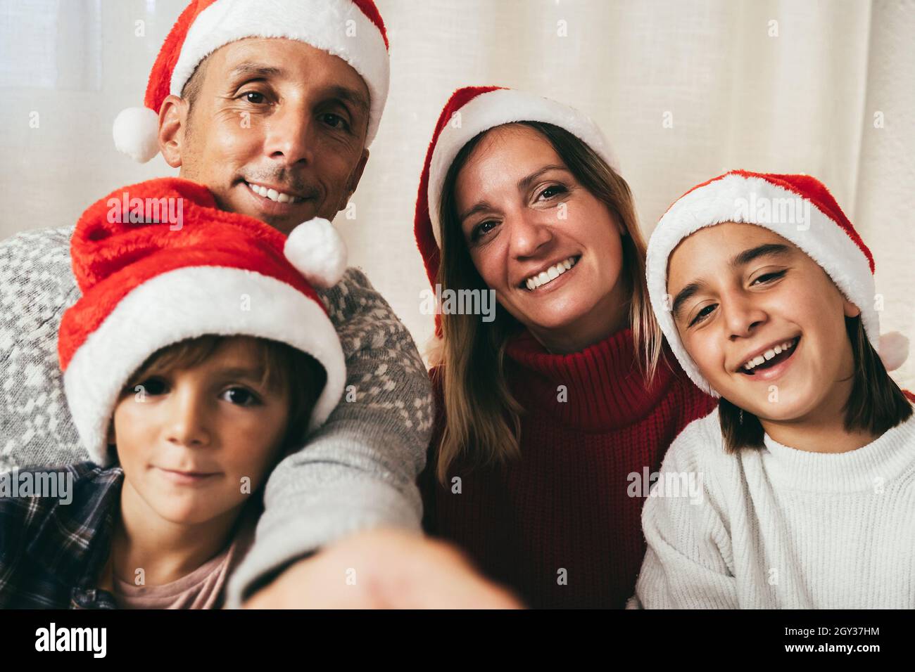Famille faisant le selfie avec le téléphone portable pendant les vacances de Noël - Père, fille et enfant s'amusant portant des chapeaux de Noël - Focus sur la fille Banque D'Images