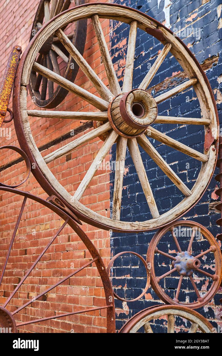 Anciennes roues de chariot dans le collage contre le bâtiment de brique Banque D'Images