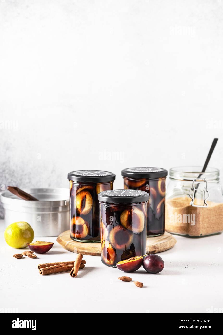 Prunes pourpres marinées faites maison dans les pots en verre avec des ingrédients.Concept d'alimentation saine.Copier l'espace. Banque D'Images