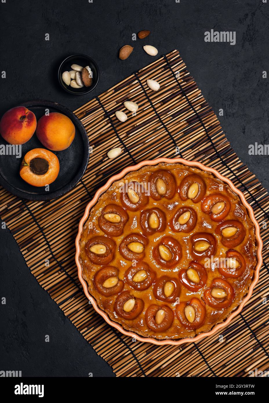 Tarte délicieuse à l'abricot avec noix d'amande sur fond sombre.Concept de cuisine maison. Banque D'Images